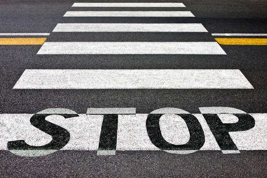 Black and white pedestrian crossing with road stop sign - concept image
