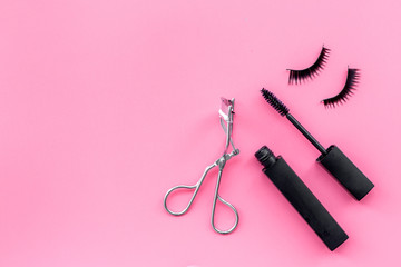 Makeup set for expressive eyelashes. Mascara, false eyelashes, eyelash curler on pink background top view space for text