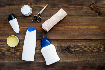 Men's bathroom set. Cosmetics and tools for body and hair care on dark wooden background top view space for text