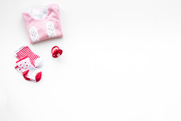 Newborn baby's background. Clothes for small girl with booties on white top view copy space