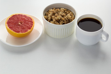 cereal,half of grapefruit and cup of black coffee  on the table