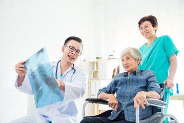 Obraz premium Asian doctor explain X-ray flim result to his patient in hospital
