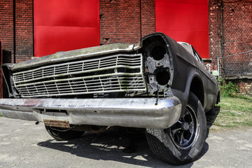 old broken muscle car on brick wall background
