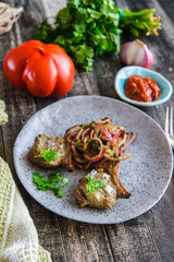 Skewers of lamb, onions and coriander on a plate top view