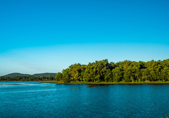 Obraz na płótnie Canvas little island in the lake with mountain and blue sky