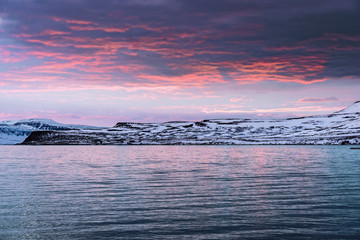 sunrise over the ocean and snowy mountains