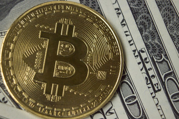 Cryptocurrency Bitcoin coin on background with dollars.