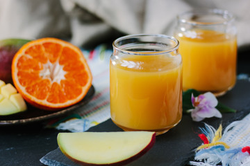 Glass filled by fresh mango and orange juice.