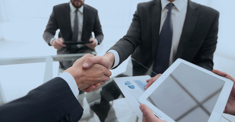 Two businessmen handshaking, congratulating on promotion. Close