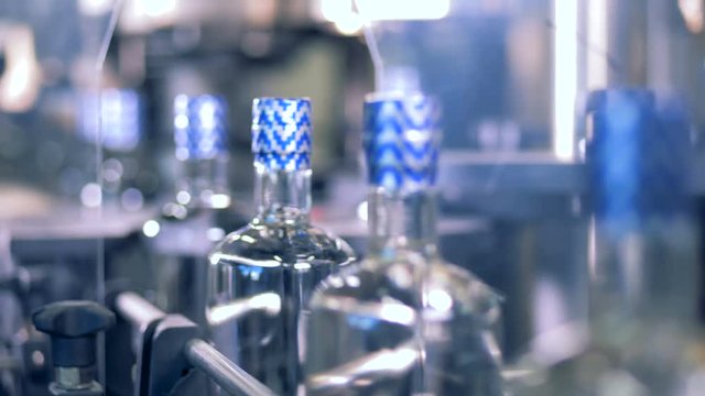 Vodka bottles with blue caps, close up.
