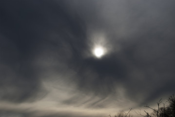 The sun is tightened by storm clouds. Dramatic sky
