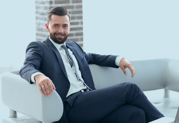 Portrait of a successful businessman sitting in the office lobby