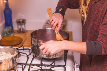 Woman Stirring Food in Stainless Steel Pot