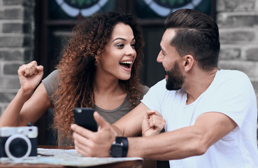 Portrait of a young  couple sitting down at a cafe terrace