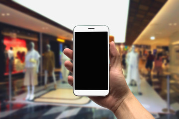 holding the mobile phone on a blurry background.