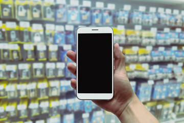 holding the mobile phone on a blurry background.