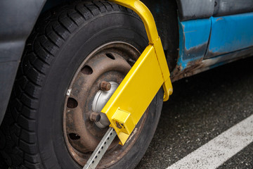 Fototapeta na wymiar yellow wheel lock device on a blue van in germany