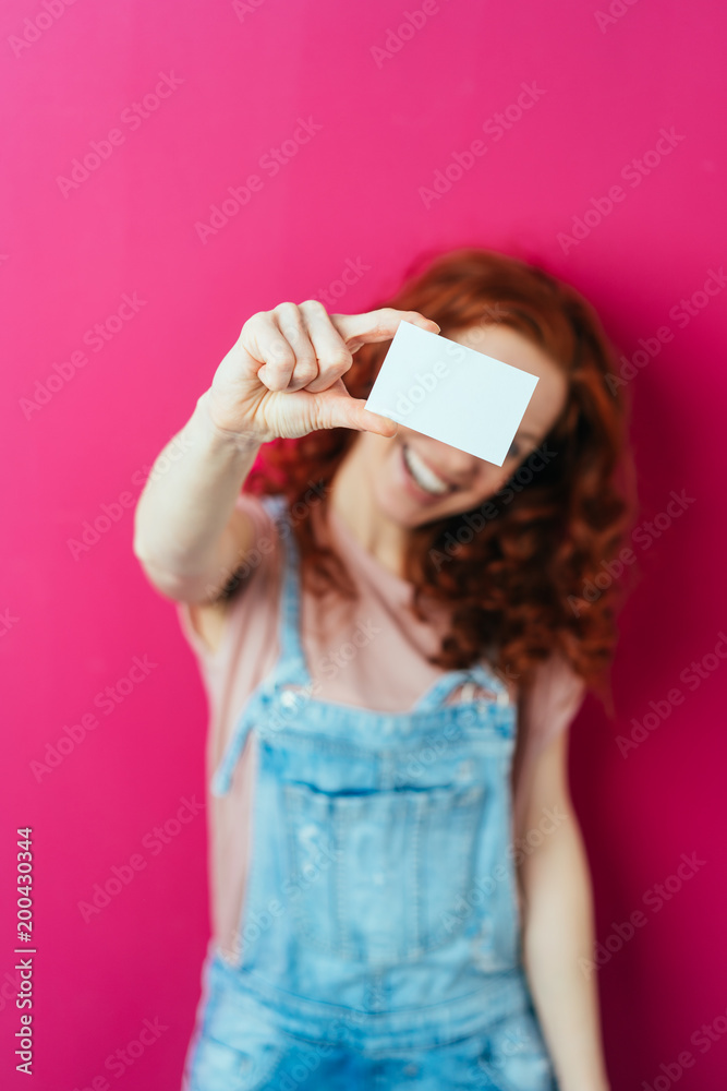 Wall mural Young smiling woman holding white blank card