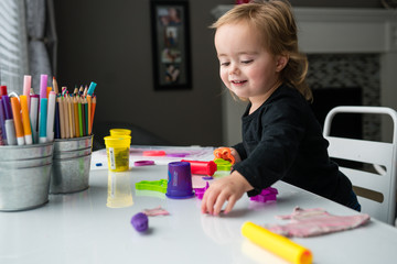 Girl playing with craft supplies at home