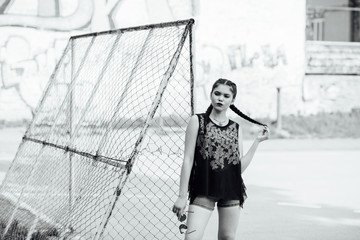 A young pretty girl walks on a football ground.