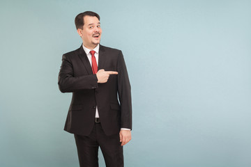 Businessman points to copy space for your advertisement.