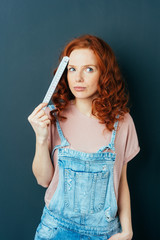 Fototapeta premium Thoughtful woman in dungarees pondering a problem