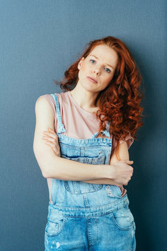 Serious calm young redhead woman with folded arms