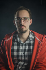 Fototapeta premium portrait of a guy in a plaid shirt with a beard. smokes electronic cigarettes. nicotine addiction
