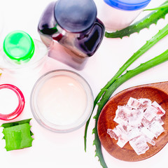 aloe vera gel and rock salt minerals skin cream on white background. organic skin care and natural cosmetic for sensitive skin. sliced aloe vera leaf. alternative medicine, spa and skin care concept.