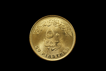 A macro image of a fifty piastre coin from Egypt isolated on a black background