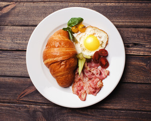 Fresh croissant with ham and salad
