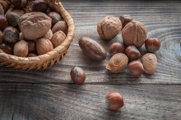 Healthy mix nuts on wooden background. Walnut, hazelnut, almond and pecan. Selective focus.