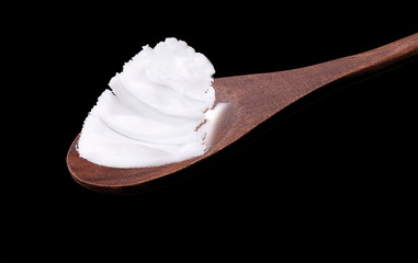 Rustic wooden spoon with pork fat, on the black background.