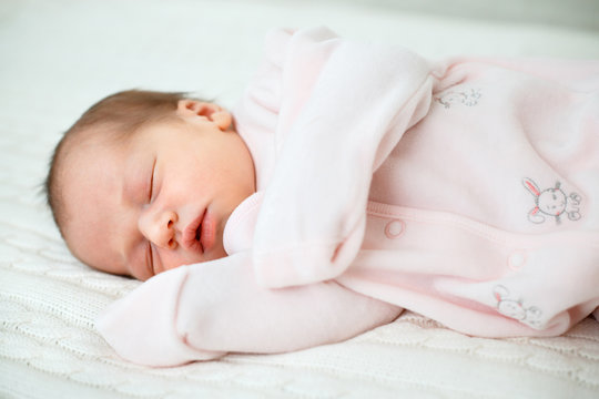 Portrait of newborn baby girl sleeping at home