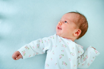 Cute two week old baby girl in cradle