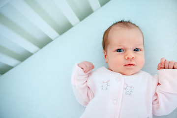 Cute two week old baby girl in cradle