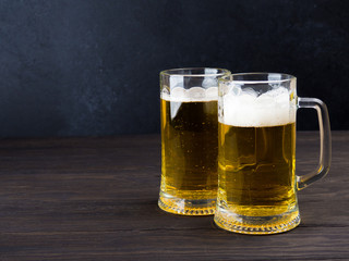 Two glasses of lager served on old wooden planks, copyspace for text