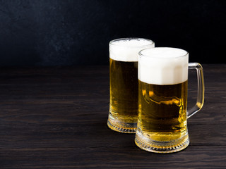 Two glasses of lager served on old wooden planks, copyspace for text