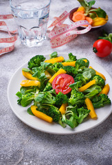 Healthy vegetable salad, water and measuring tape