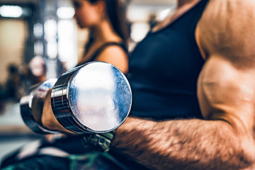 Male athlete doing biceps exercise with dumbbells