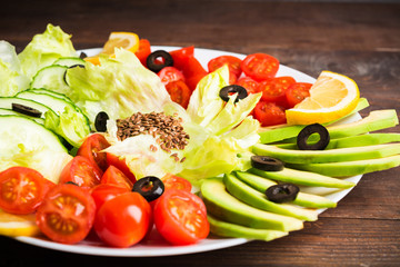 Raw vegetables on white plate, salad bar