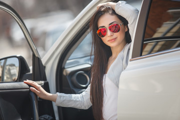 Naklejka premium Very beautiful woman in the car holding flowers