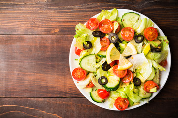 Raw vegetables salad with tomato, cucumber, lettuce and avocado