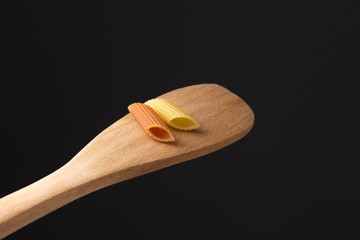 zwei Nudeln rot gelb auf Holzlöffel