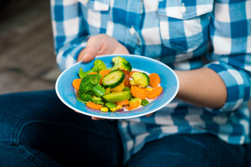 Girl with a plate of vegetables in hands