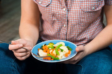 Girl with a plate of vegetables in hands