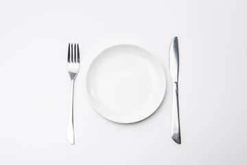White empty plate with fork and knife