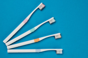 Toothbrushes on empty blue background, top view. Dental equipment, oral health care concept.