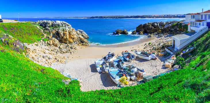 Wonderful romantic afternoon panoramic landscape. Coastline of island Baleal of the Atlantic ocean near Peniche. Fishing boat boats on the sandy shore on beach. West coast of Portugal at sunny weather