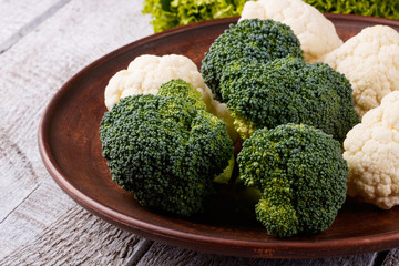 broccoli and cauliflower in a plate on a wooden table